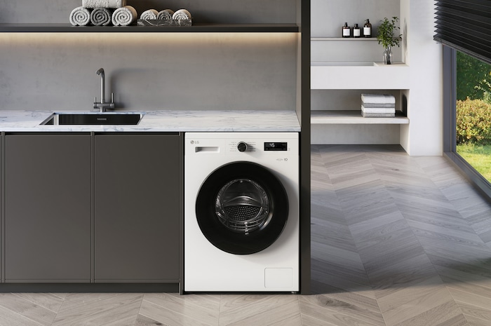De LG 9 kg wasmachine F4X1009NWB in Essence White, ingebouwd onder het aanrecht in een moderne wasruimte.
