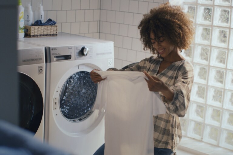 Een vrouw geniet van schone kleren in de wasruimte