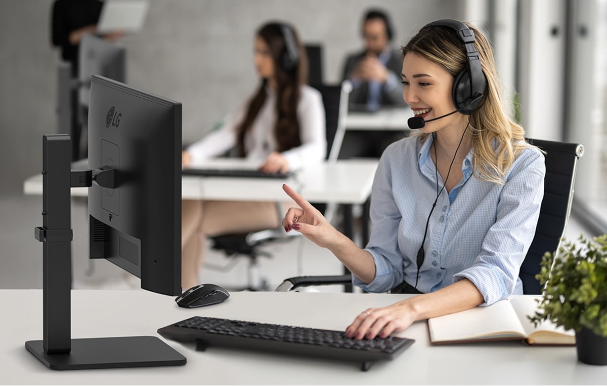 Een vrouw met een headset in een callcenter in gesprek met een klant.