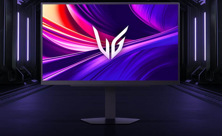 Vooraanzicht van de LG UltraGear™ 27G810A gamingmonitor op zijn zeshoekige voet, geplaatst in een futuristische, neonverlichte gang; het scherm toont levendige paarse en rode wervelingen met het UltraGear-logo in het midden.