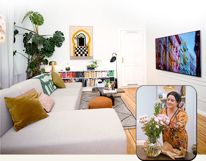 Een panoramisch uitzicht op de woonkamer met een tv is zichtbaar en een gelaagde foto van een vrouw die bloemen schikt is eroverheen gelegd.	