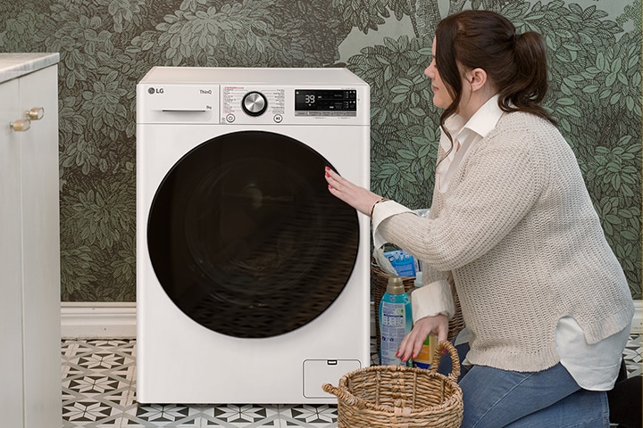De video toont de vrouw die wasgoed in de wasmachine doet, de vrouw die de wasmachine bedient en de knop van de wasmachine.	