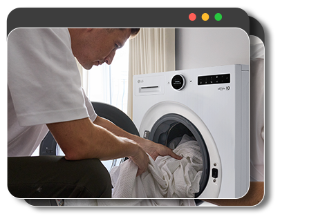 Gebruiker die kleding in de wasmachine doet en via een smartphone-app op afstand het wasprogramma start.