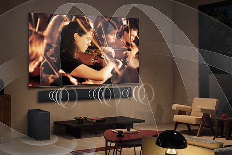 An image of an LG TV and LG Soundbar in a black room playing a musical performance. White droplets representing soundwaves shoot upwards and forward from the soundbar like a waterfall.