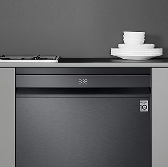 Kitchen interior with partially open free-standing dishwasher and LG ThinQ® app showing cycle complete notification.