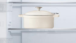 Close up view of a beige pot placed on top of the tempered glass shelf inside LG French Door Fridge.