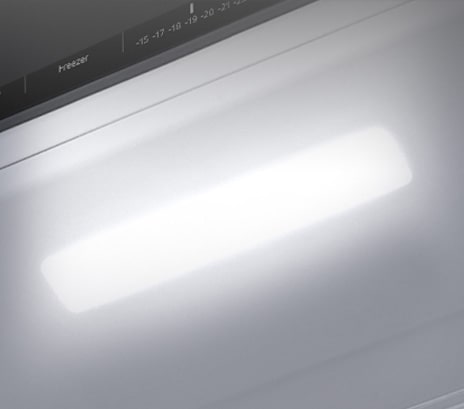 The top interior of the fridge is shown with the soft LED light bright.