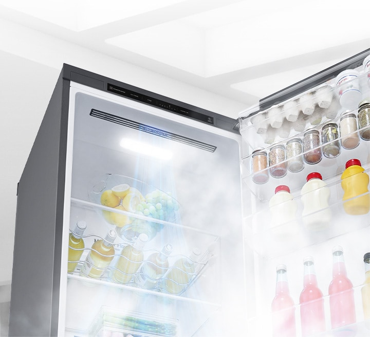 The refrigerator is shown open at an angle and filled with produce. White air is blowing from the top of the interior down around all of the food to keep it cool.	