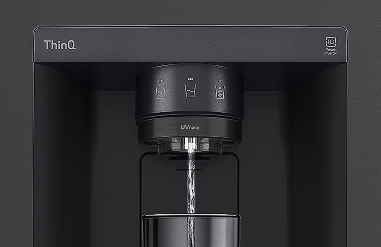 A video starts zoomed in on the water dispenser. The exterior of the refrigerator goes clear and now the interior of the door and mechanical parts of the dispenser nozzle can be seen. The video zooms in further to show the water droplets as they fall through the UVnano part of the nozzle which reduces the bacteria. The view zooms back out to see the exterior of the refrigerator again as water is being dispensed into a glass.