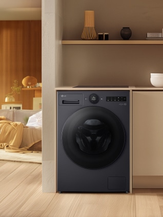 In the laundry room next to the living room, a black LG washing machine is placed inside a wood-tone cabinet.
