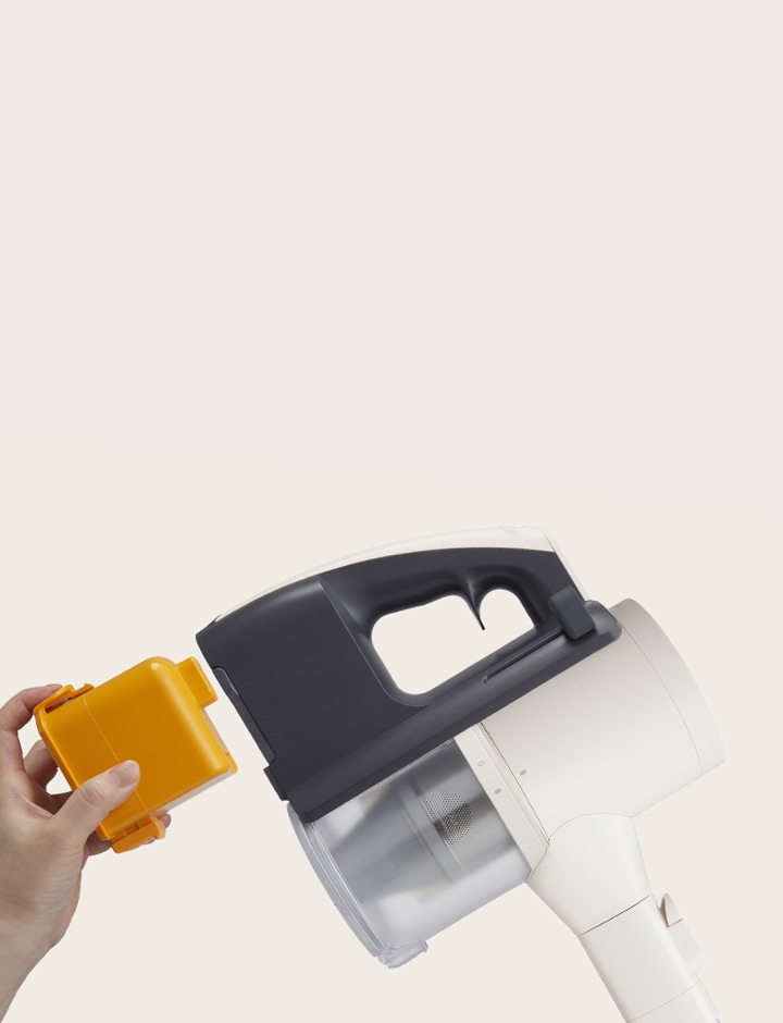 Hand with yellow battery approaching battery compartment