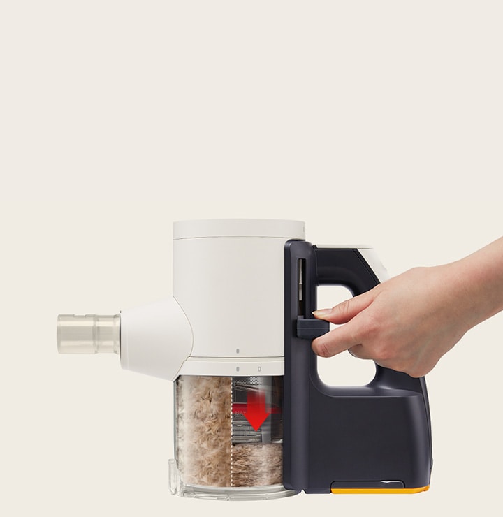 Hand pressing LG A9 Kompressor™ to compress collected dust, showing red arrow indicating compacted bin.