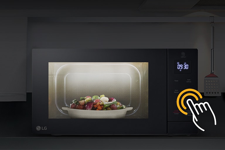 LG microwave with vegetable dish heating, control panel shows 03:30 with a hand icon indicating touch operation.