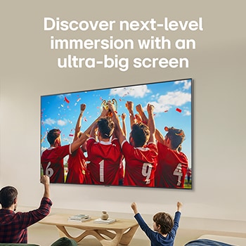 LG QNED AI QNED70 Mini LED Ultra Big TV is wall-mounted in a bright living room, showing an intense soccer moment with vivid colors and refined picture quality across a wide screen, as a family seated on sofas cheers together.