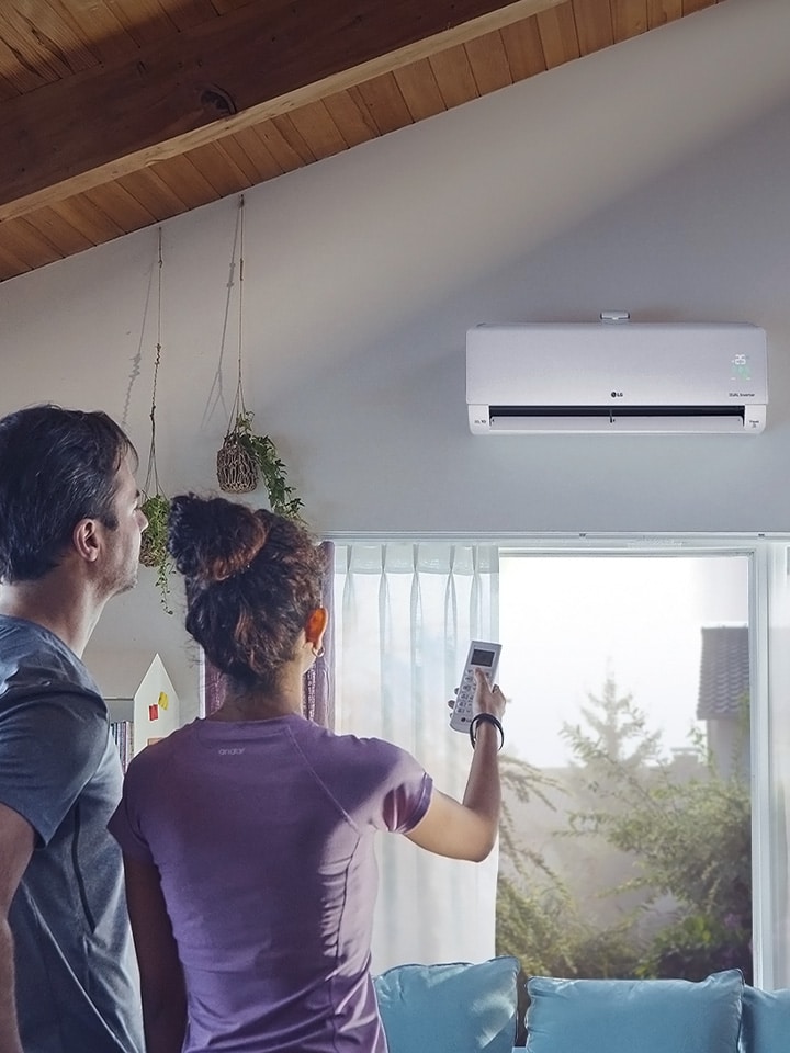 This is an image showing a man and a woman operating an air conditioner.