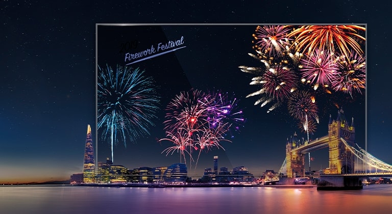 LG Transparent OLED Signage muestra vívidamente los fuegos artificiales, haciendo que la pantalla se vea más colorida en armonía con la vista nocturna real detrás de ella.