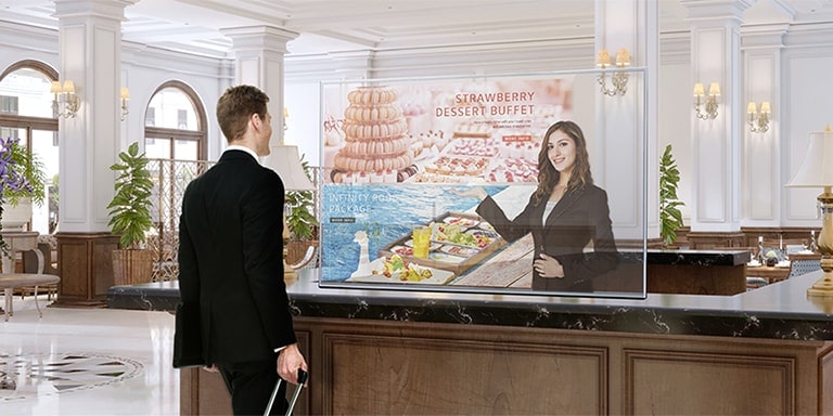 Un hombre obtiene información a través de la pantalla OLED transparente que muestra fotos del menú de postres.