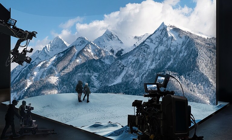 Un estudio de producción virtual con paredes curvas de LED y LED de techo y piso está capturando video de un escenario de montaña con nieve.