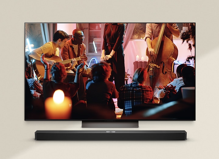 La escena de un concierto se está reproduciendo en la TV y una Soundbar está colocada debajo de la TV.