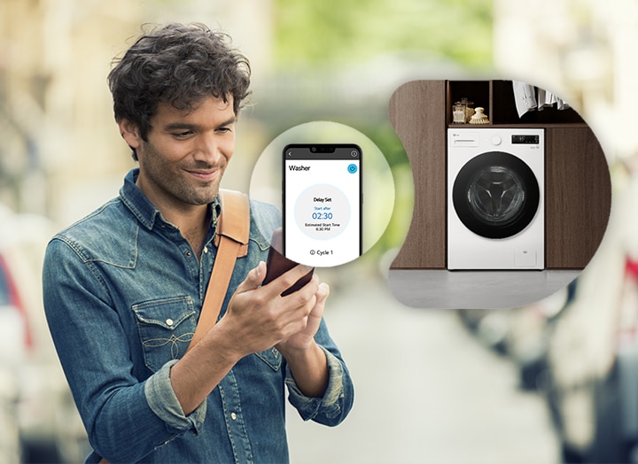 El hombre está mirando el teléfono inteligente y muestra la pantalla y la imagen de la lavadora del teléfono inteligente junto a él.