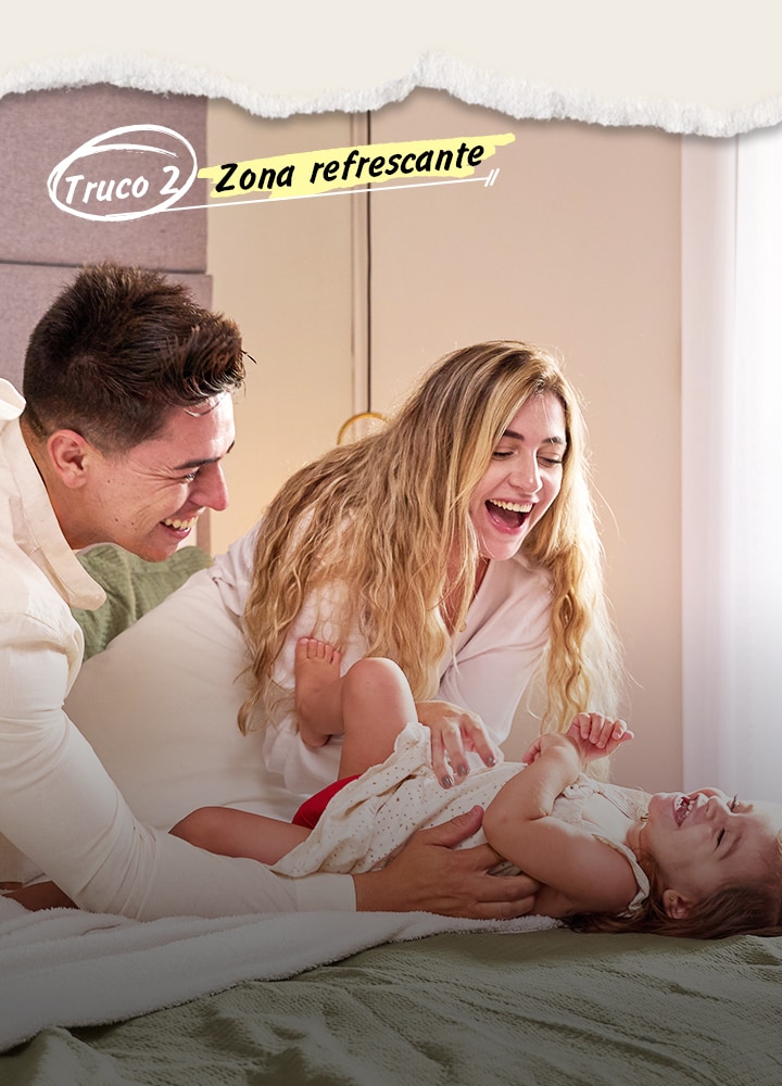 Padres jugando con su bebé en la cama.