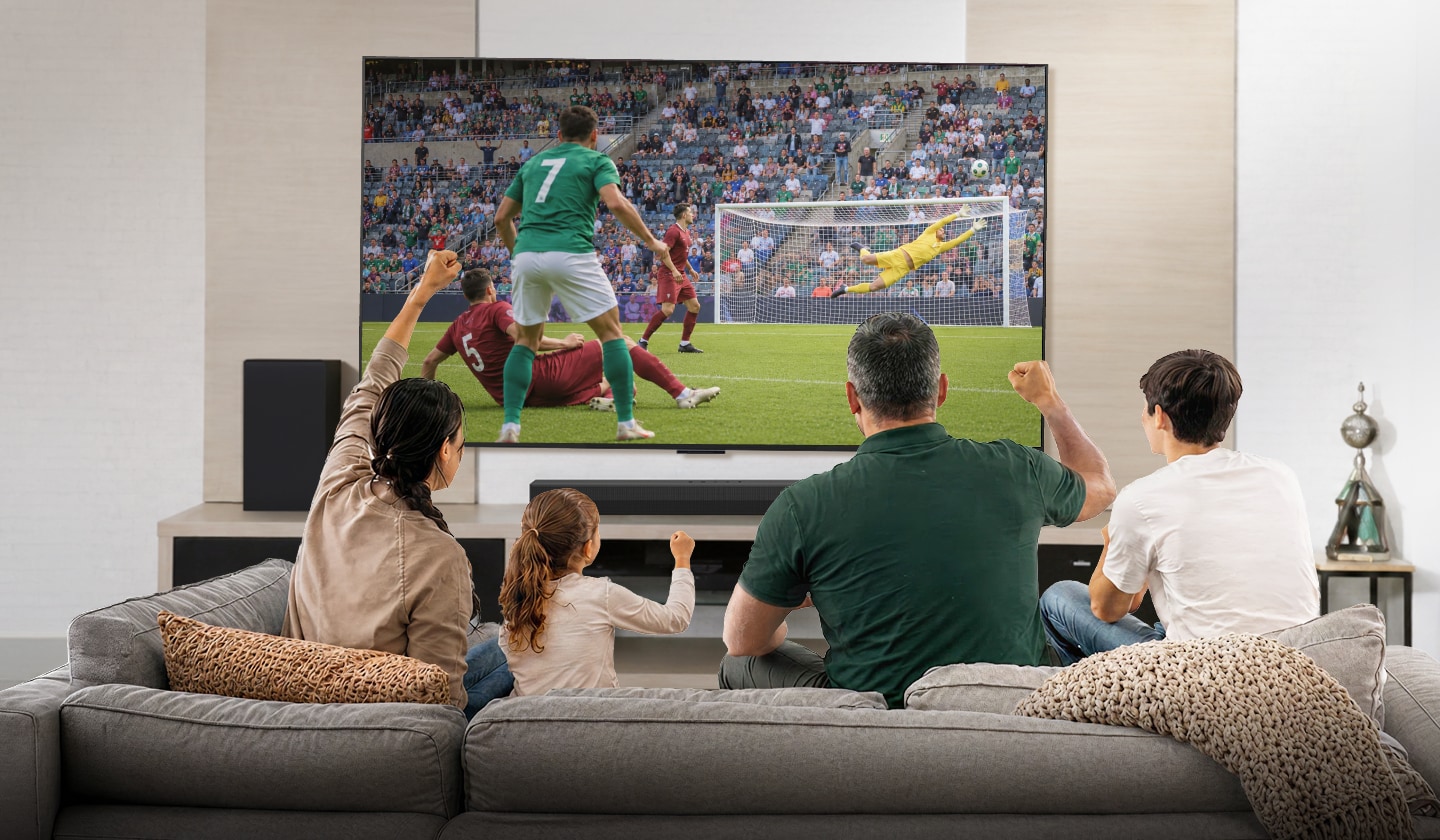 Una familia ve un partido de fútbol en una TV LG de gran tamaño en la sala.