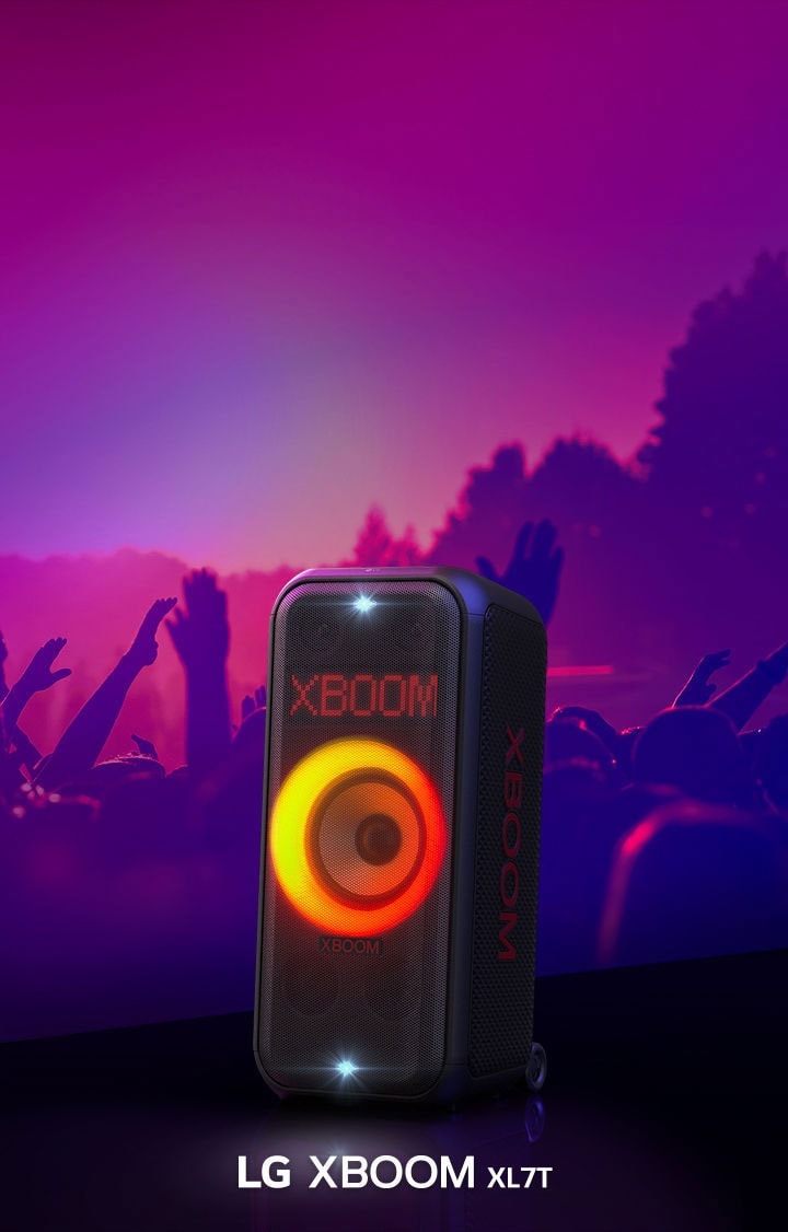 El LG XBOOM XL7T está en el escenario con luz rojo-anaranjada, mientras el público detrás disfruta de la música.