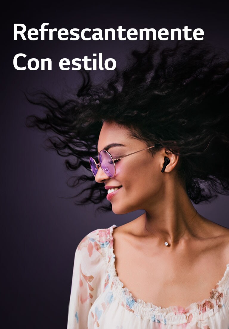 Una mujer sonríe mientras escucha música con TONE Free.