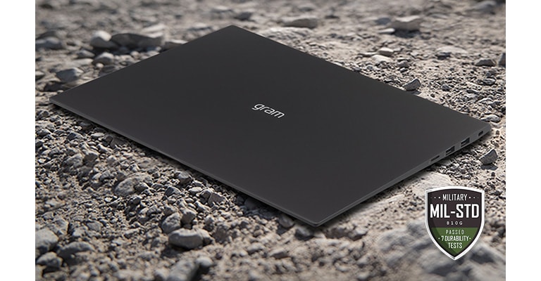 Muestra LG gram en el suelo con arena y piedras.