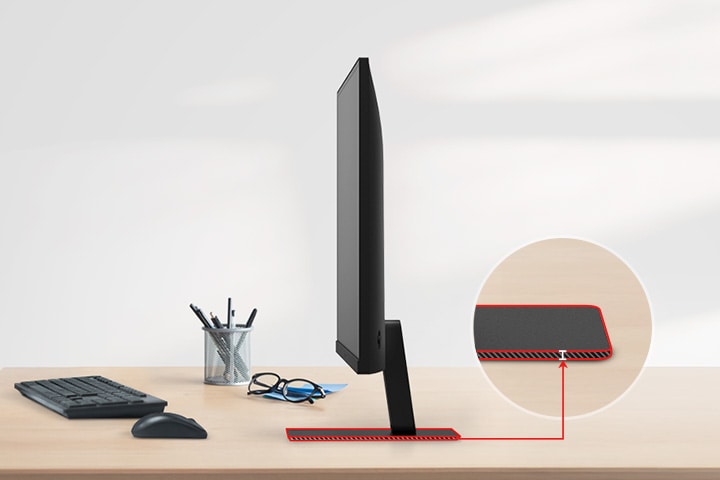 A QHD monitor with a super slim stand is on the desk, with a pencil holder, glasses, a keyboard, and a mouse next to it.