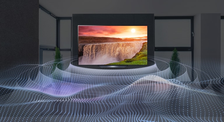 Un gran televisor de pantalla plana en una habitación oscura con una cascada brillante al atardecer que se muestra en la pantalla. Las ondas salen del televisor en un patrón circular que representa el sonido envolvente virtual.