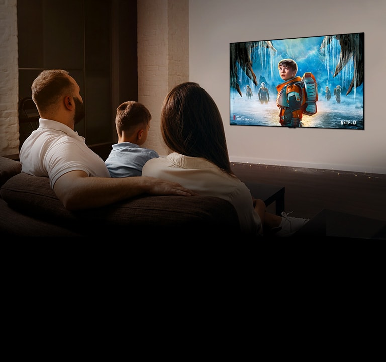 Pareja sentada en un sofá en la sala de estar mirando una película romántica en la TV