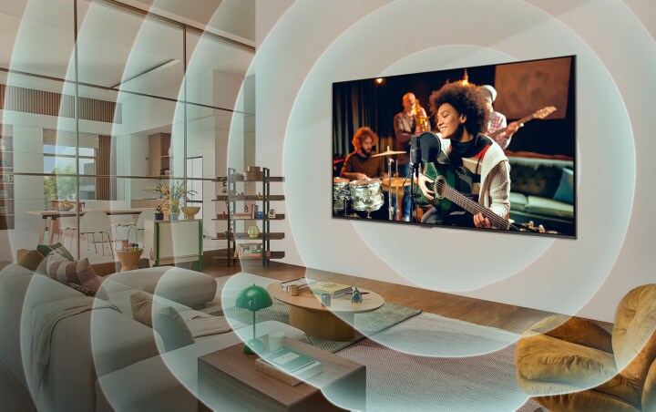 Televisor LG montado en la pared de una sala de estar con un guitarrista mostrado en la pantalla. Gráficos de círculos concéntricos que representan ondas sonoras.	