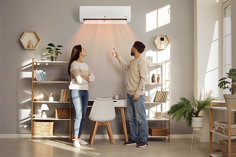 Una pareja usando el Aire Acondicionado LG de su hogar