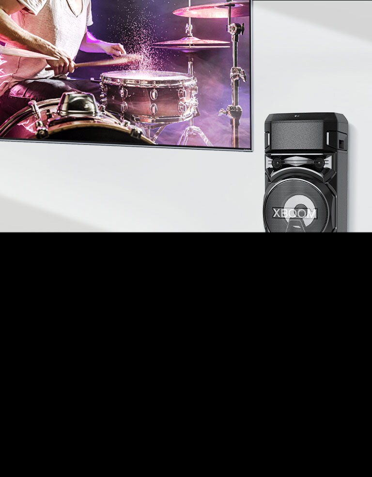 A TV is on a wall with an LG XBOOM to the right of it.