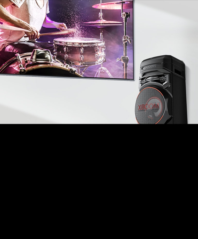A TV is on a wall with an LG XBOOM to the right of it.