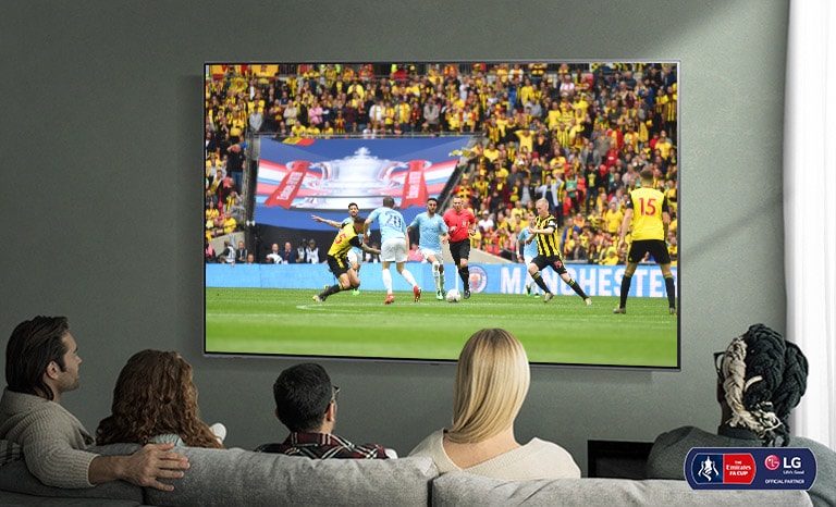 A family of five is watching a soccer game on a NanoCell TV.