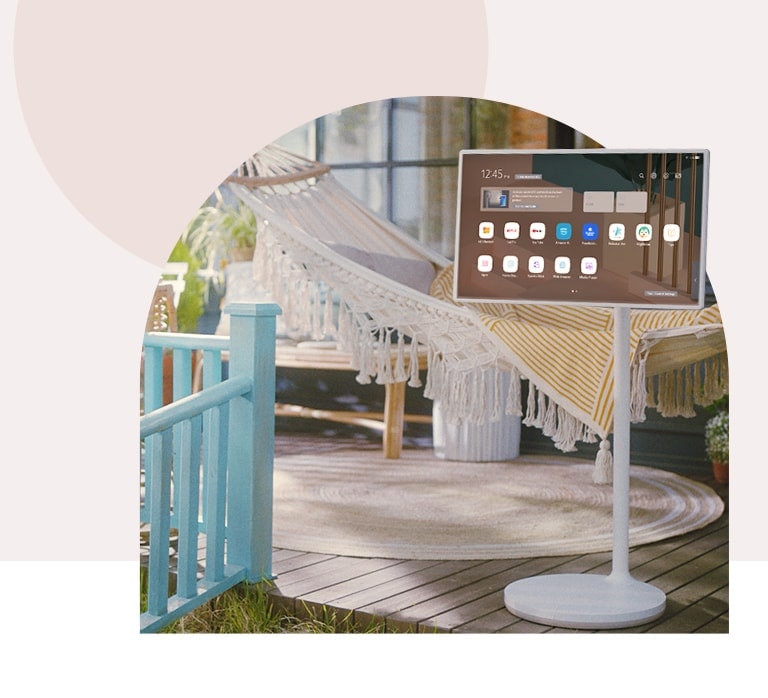 TV is placed in front of hammock in terrace. The image is cropped in arch-shape.