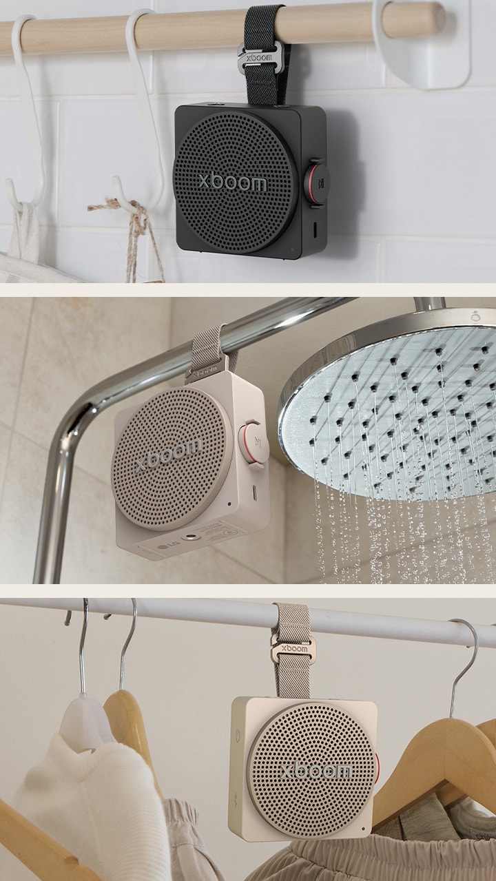 1) LG xboom mini black-colored, a portable bluetooth speaker with a strong hanging strap on a kitchen rail 2) LG xboom mini beige-colored, a mini, cube designed bluetooth speaker with a strap hanging on a clothing rack with hangers 3) LG xboom mini black-colored, a small portable bluetooth speaker hanging from a shower bar in a bathroom
