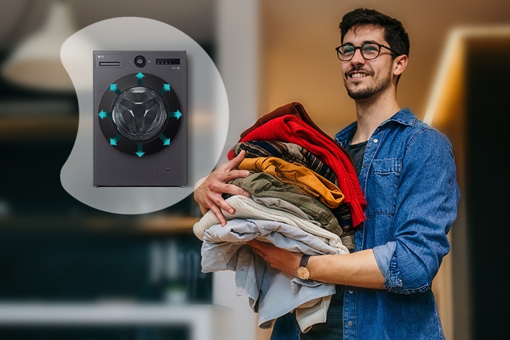 He's standing with the finished laundry, and next to him, he's showing a larger image of the interior of the washing machine	