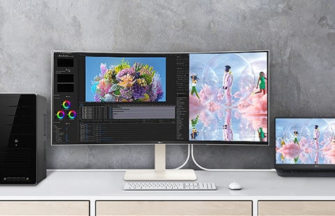 On the desk, there's an UltraWide monitor placed, with the screen divided in half. On the left side, there's a display of work being done on the desktop, while on the right side, the same work is being carried out on a laptop.