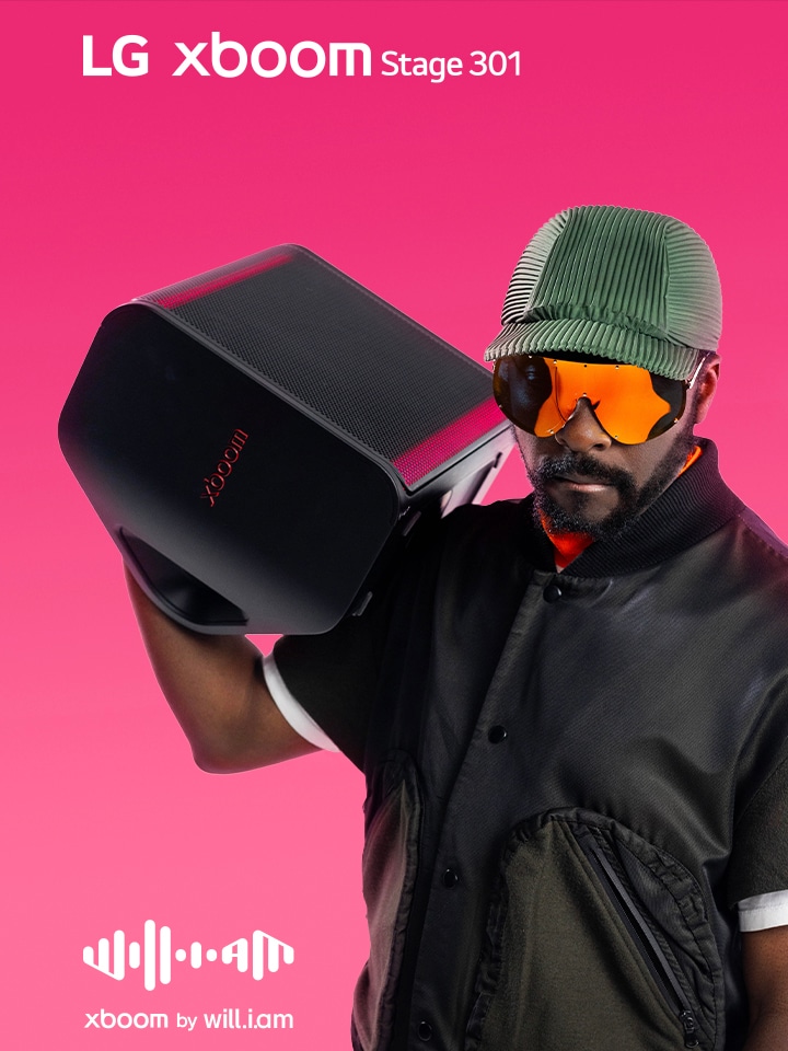 will.i.am in black outfit and sunglasses is holding xboom Stage 301 on his shoulder.	