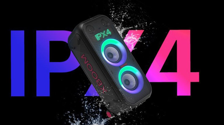 Widok głośnika pod kątem. Produkt jest spryskiwany wodą, aby podkreślić stopień ochrony IPX4. Słowo „IPX4” jest napisane z tyłu ze względów projektowych.