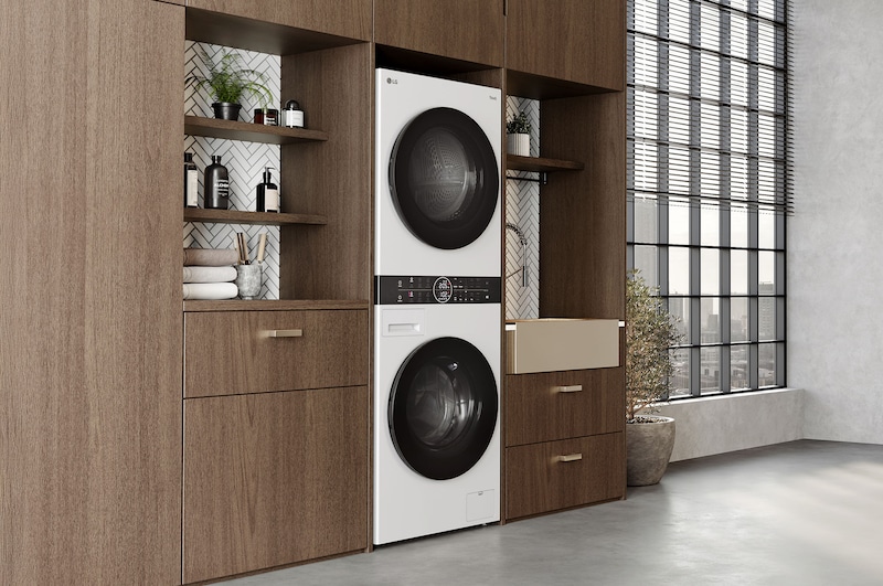 LG WashTower WT1210WWF w kolorze czarnym, elegancko zabudowana w nowoczesnej, drewnianej szafie pralniczej.