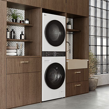 LG WashTower WT1210WWF w kolorze czarnym, elegancko zabudowana w nowoczesnej, drewnianej szafie pralniczej.