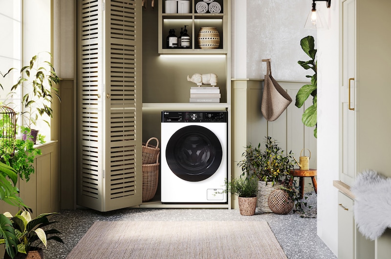 Biała pralko-suszarka 11/6 kg LG F4D1675YW z czarnymi drzwiami, w nowoczesnej i przytulnej pralni.