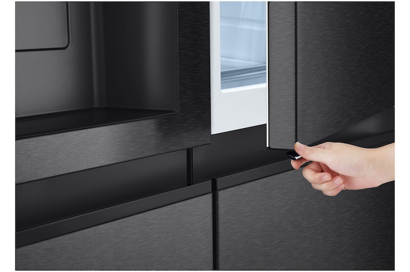Zbliżenie użytkownika otwierającego panel InstaView za pomocą dolnego uchwytu podkreślające płynny mechanizm otwierania oraz eleganckie wykończenie zewnętrznej powierzchni lodówki.