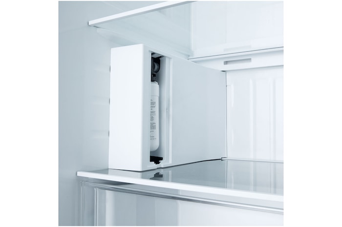 Powiększony widok komory wewnętrznego filtra wody prezentujący pionową obudowę i prowadzenie wkładu zaprojektowane dla łatwej wymiany oraz estetycznej integracji wewnątrz lodówki.