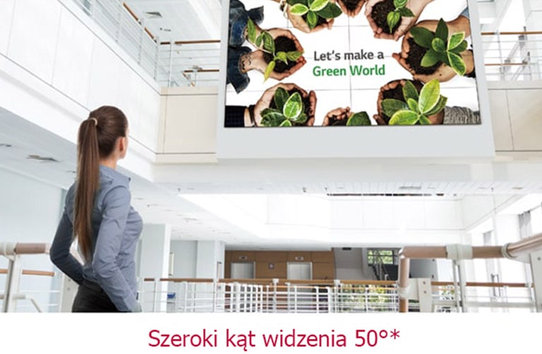 Kobieta patrząca na ekran zainstalowany na górze.