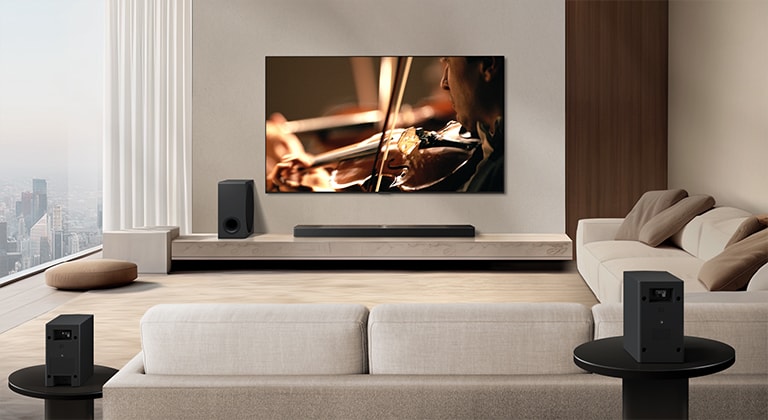 LG Soundbar, LG TV, subwoofer i tylne głośniki w nowoczesnym, miejskim apartamencie. Tło przygasa, a nakładka siatki pojawia się nad obrazem z LG TV, niczym skan przestrzeni. Przerywana linia rozciąga się od jednego z tylnych głośników, aby pokazać, że dwa tylne głośniki są ułożone liniowo. Białe fale dźwiękowe składające się z kropelek wydobywają się z przedniej perspektywy tylnych głośników.